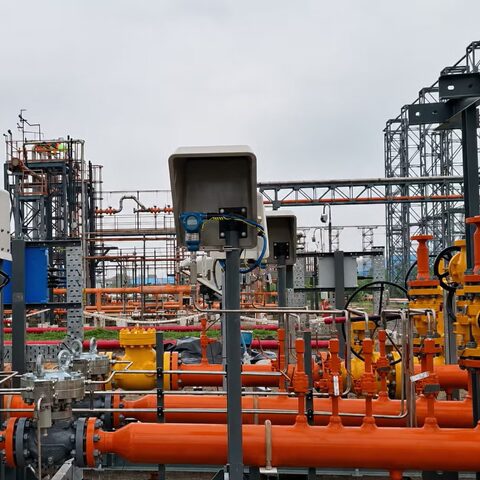 Electrical and instrumentation systems integrated with industrial control pipework at a processing facility.